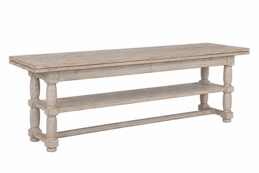 Rustic whitewashed wood console table with turned legs, lower shelf, stretcher base, and distressed gray-white finish evoking vintage farmhouse charm.