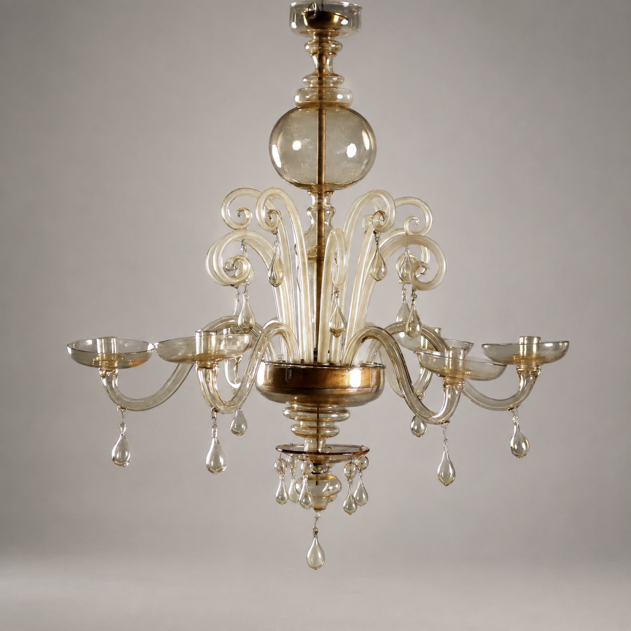 Venetian Murano glass chandelier with 6 scroll arms, amber-gold tint, teardrop pendants, decorative globe, and cup-shaped candle holders in elegant traditional style
