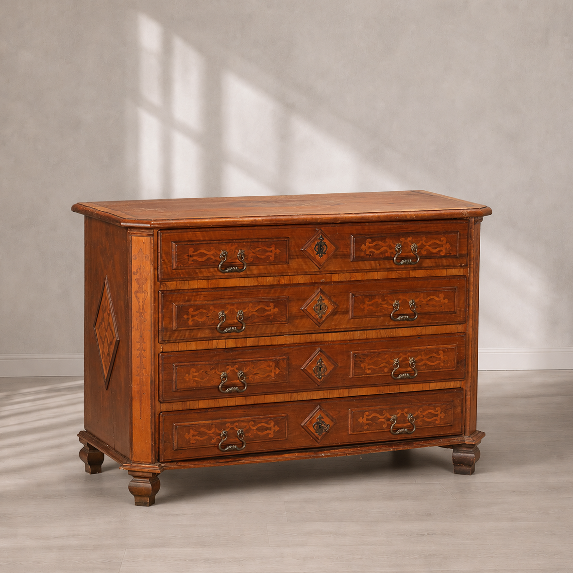 Antique Italian-style walnut chest of drawers with four drawers, marquetry inlay floral and scroll motifs, diamond keyhole escutcheons, brass bail handles, and turned bun feet.