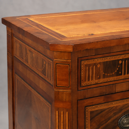Antique-style mahogany chest of drawers with intricate marquetry inlay, banded top, dotted string borders, fluted pilasters, and oval brass hardware on lower drawer.