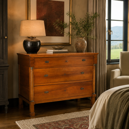 Antique-style three-drawer wooden chest in warm honey oak with oval brass hardware, tapered legs, and column accents. Classic European commode design with rich grain detail.