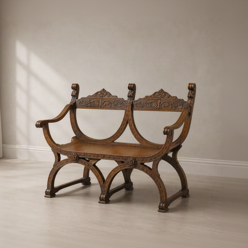 Antique-style carved wooden bench with ornate scrollwork backrest, curved X-frame legs, decorative nail head trim, and dual seat design in rich walnut brown finish.