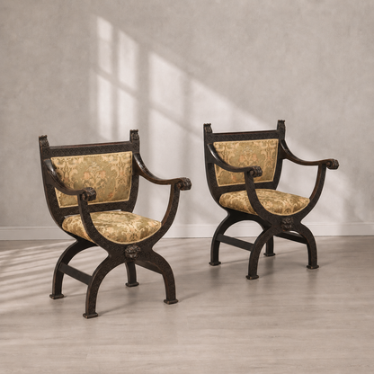Pair of ornate Renaissance-style Curule armchairs with dark walnut carved frames, X-base legs, lion head accents, and gold damask upholstered seat and back cushions.