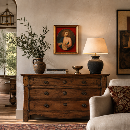 Antique dark brown wooden dresser with three drawers, ornate ring pulls, distressed finish, topped with ceramic vase, lamp, and decorative bowl in rustic living room.