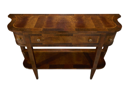 Traditional walnut console table with curved edges, brass drawer pulls, single center drawer, and lower shelf storage. Features rich wood grain patterns and elegant curved design.