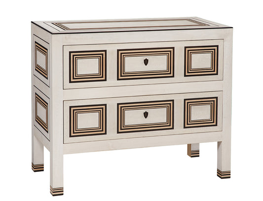 White wooden chest with two drawers featuring geometric inlay patterns in dark brown and gold trim. Raised on four straight legs with matching decorative banding details.
