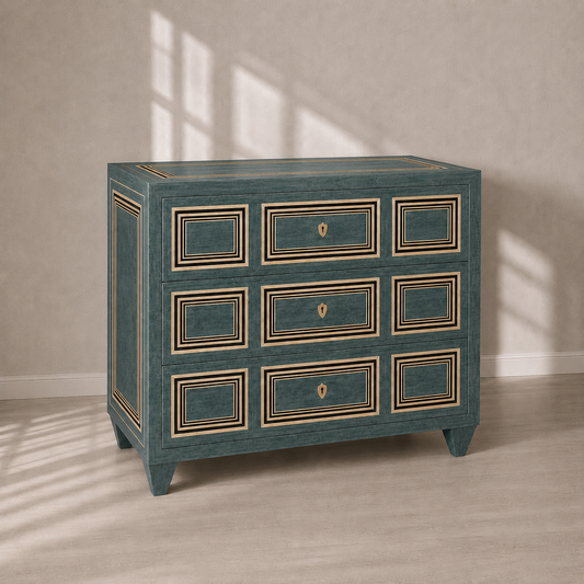 Teal three-drawer chest with gold and black geometric molding details, shield-shaped brass keyhole pulls, tapered legs, and elegant neoclassical panel inlay design.
