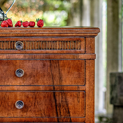 Wooden chest of drawers with rich brown finish featuring three drawers with round metal knobs, decorative fluted trim detail on top drawer, and classic traditional styling