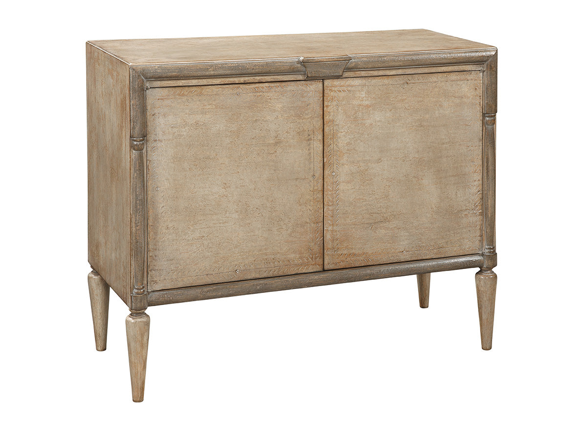 Light brown wooden sideboard with distressed finish, featuring two cabinet doors, decorative molding details, and tapered legs in a traditional style