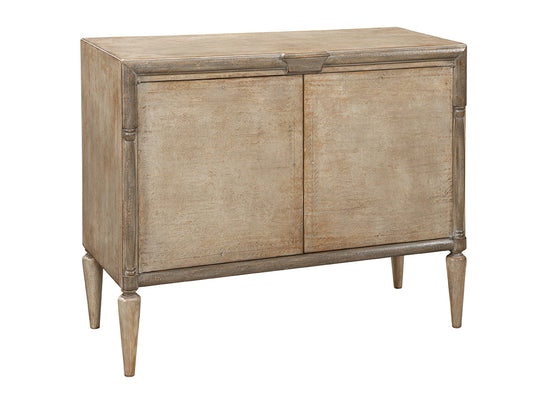 Light brown wooden sideboard with distressed finish, featuring two cabinet doors, decorative molding details, and tapered legs in a traditional style