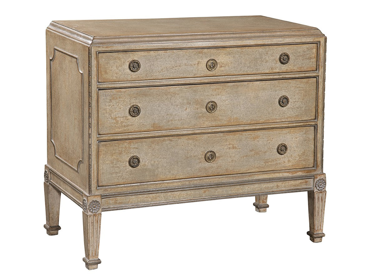 Three-drawer chest in weathered taupe finish with ornate brass circular hardware, featuring decorative carved legs, rope-style trim, and traditional neoclassical design elements