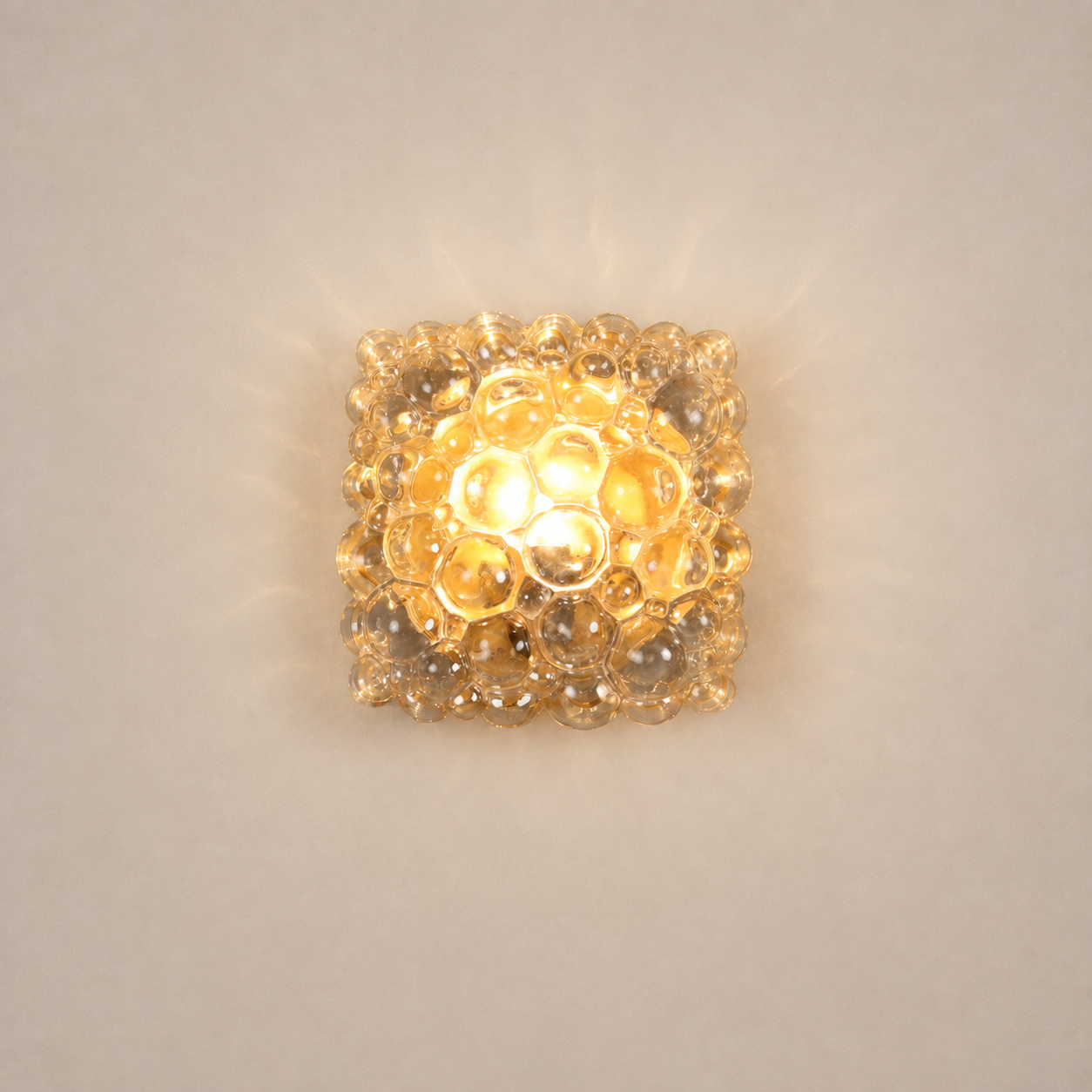 Square bubble glass wall sconce with warm amber glow, featuring textured clear glass spheres arranged in a honeycomb pattern, flush-mount mid-century modern light fixture