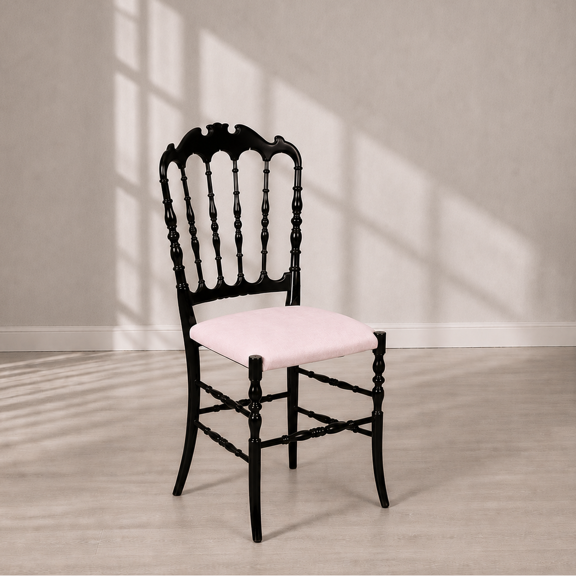 Victorian-style dining chair with glossy black wood frame featuring ornate spindle back and carved crest rail, paired with a soft blush pink upholstered seat cushion.
