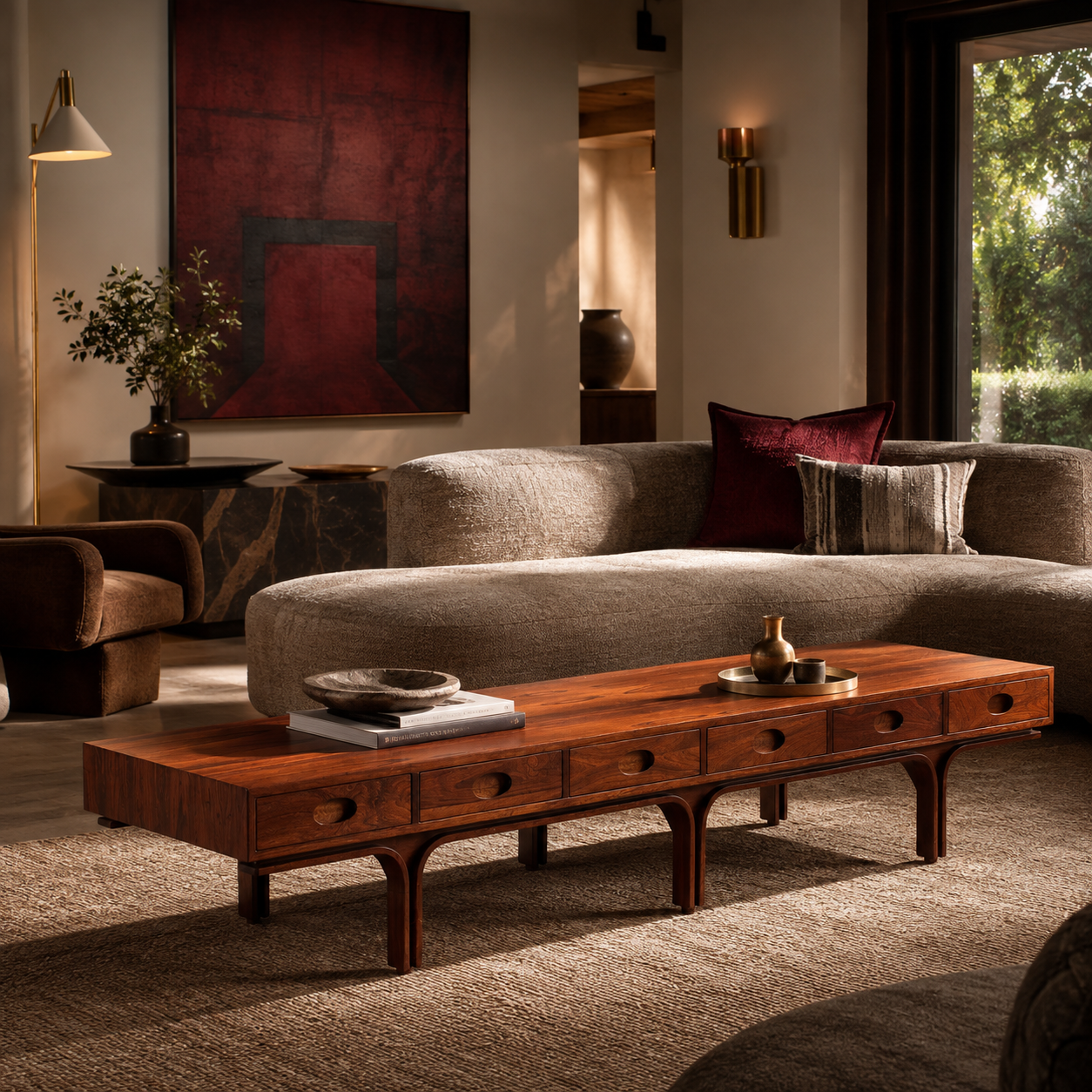Mid-Century modern rectangular coffee table in rich walnut wood with circular drawer pulls, arched legs, and low-profile design, styled with books and decorative objects.
