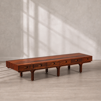 Mid-Century modern low-profile rosewood coffee table with five oval pull drawers, arched leg base, and rich warm brown grain finish, approximately 7 feet long.