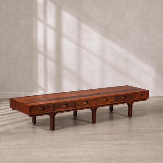 Mid-Century modern low-profile rosewood coffee table with five oval pull drawers, arched leg base, and rich warm brown grain finish, approximately 7 feet long.