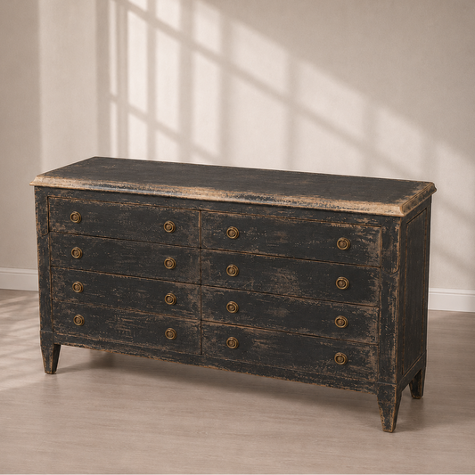 Distressed black 8-drawer double dresser with antique brass round knobs, weathered wood finish revealing cream undertones, tapered legs, rustic farmhouse style.