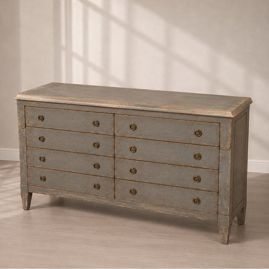 Distressed gray wood double dresser with 8 drawers, antique brass round knobs, tapered legs, and weathered finish in French country style